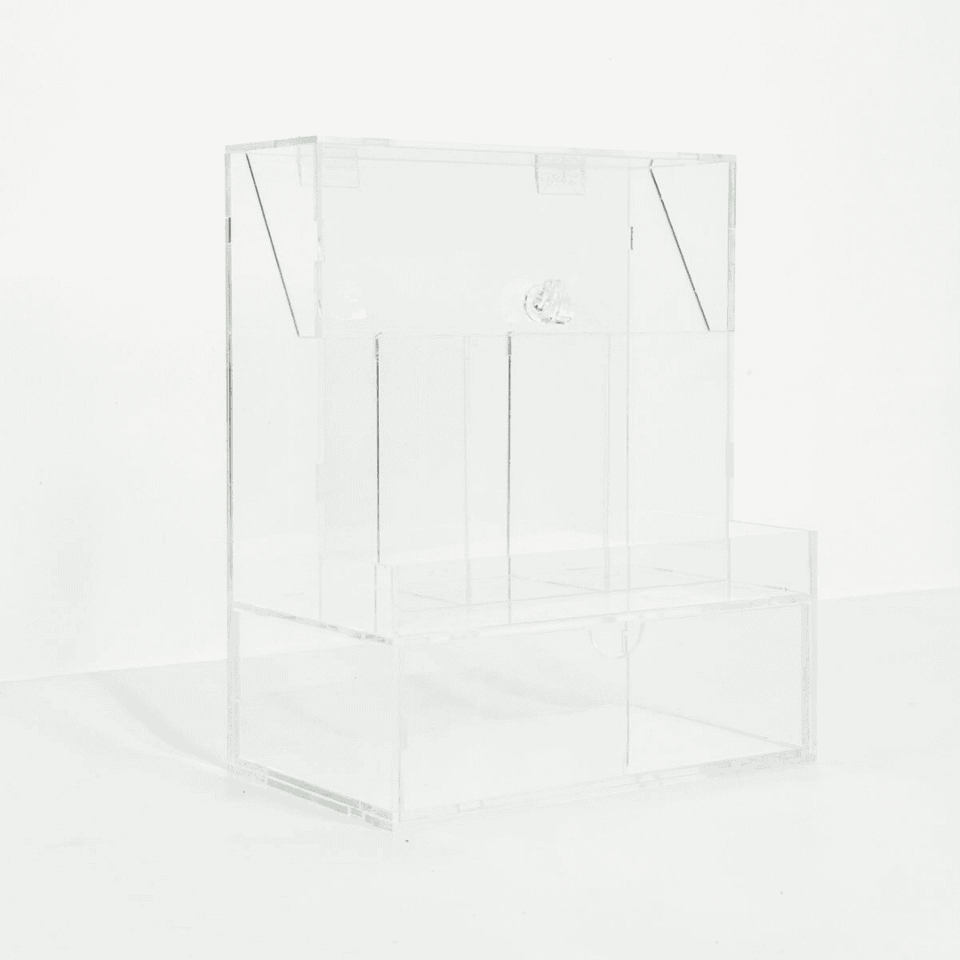 Clear acrylic makeup organizer with various cosmetic items on a white surface.
